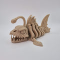 Angled front view of a bone-coloured 3D-printed articulating skeleton Anglerfish toy