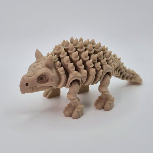 Angled front view of a bone-coloured 3D-printed articulating skeleton Ankylosaurus toy