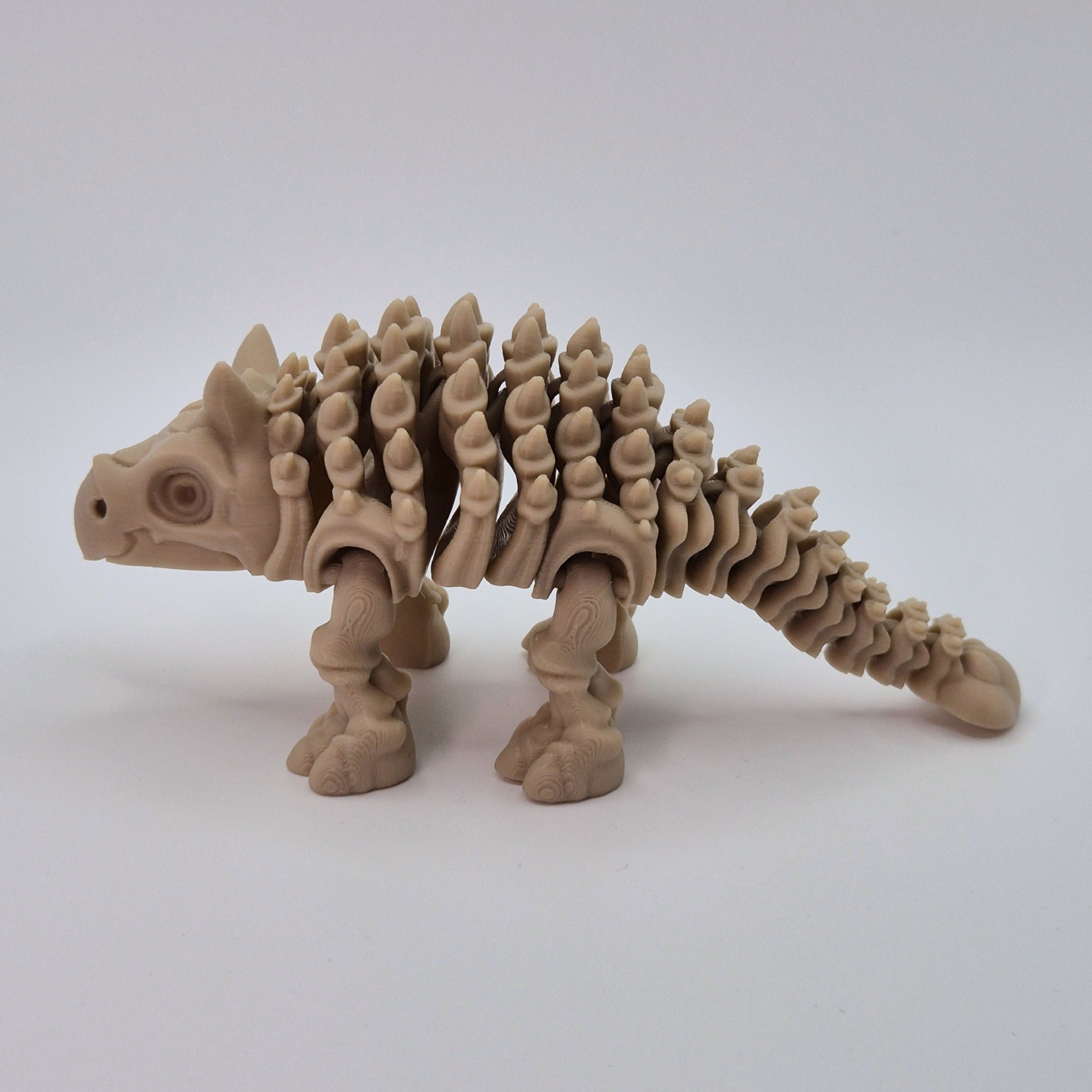   Side view of a bone-coloured 3D-printed articulating skeleton Ankylosaurus toy