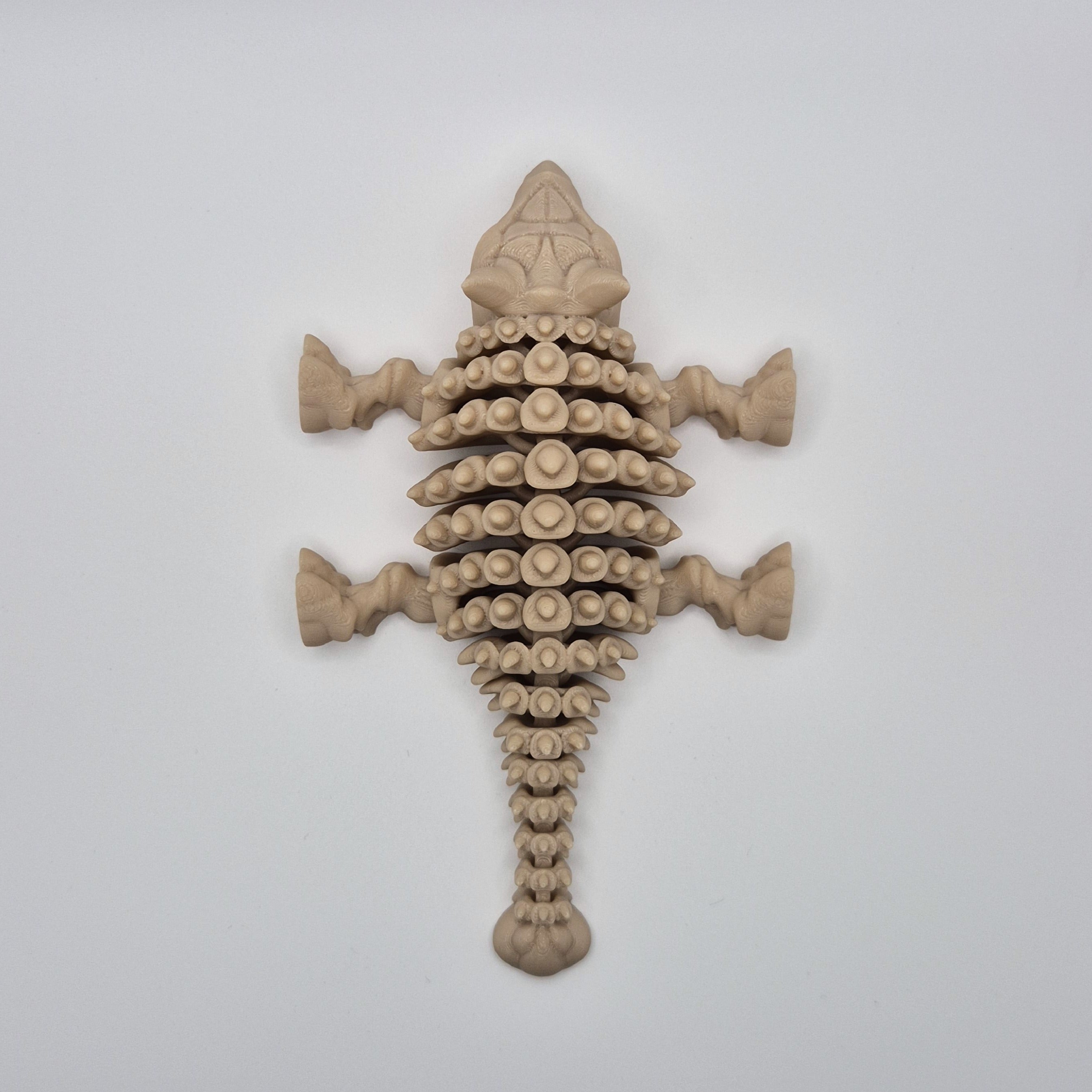 Top-down view of a bone-coloured 3D-printed articulating skeleton Ankylosaurus toy