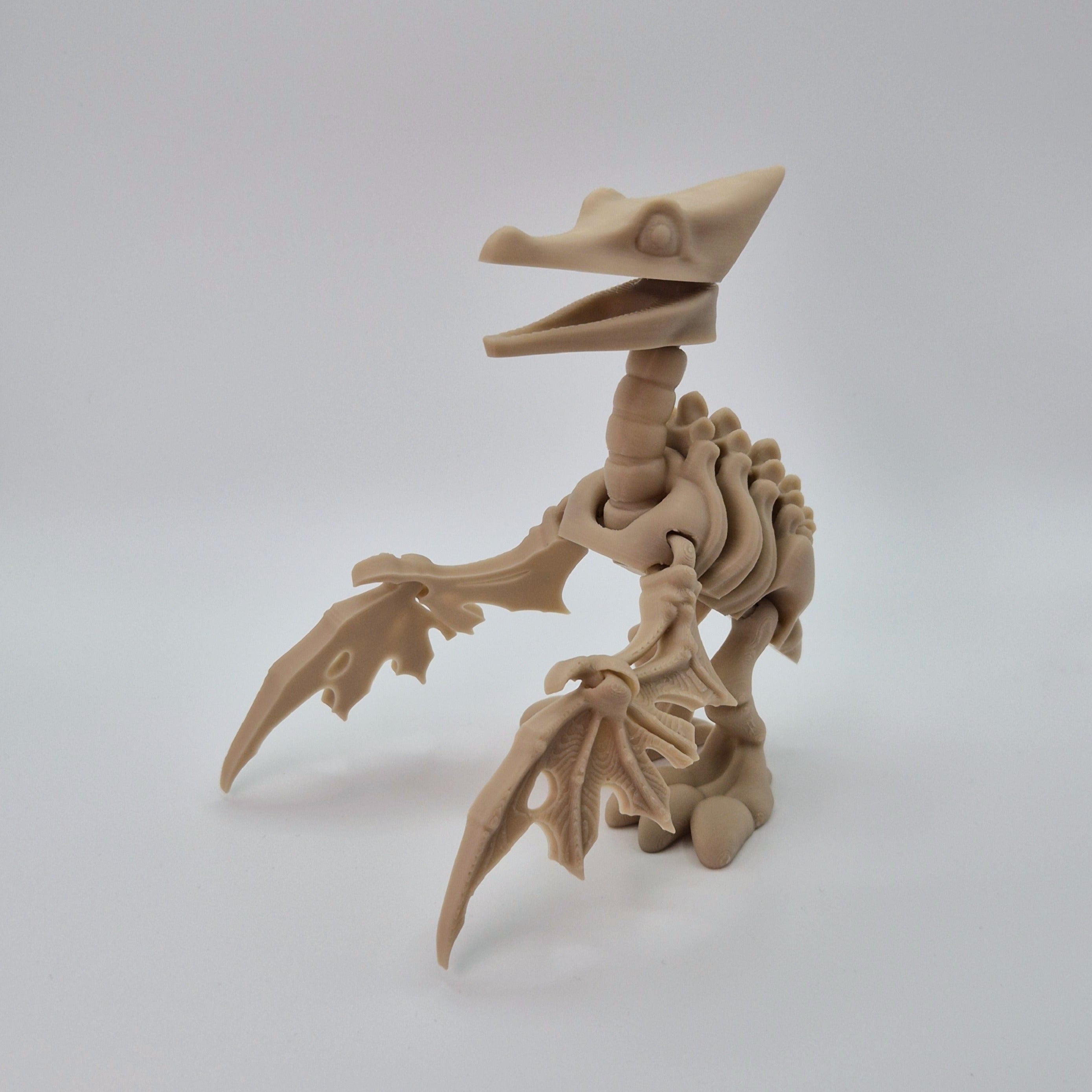 Angled front view of a bone-coloured 3D-printed articulating skeleton Pteranodon toy