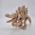 Angled front view of a bone-coloured 3D-printed articulating skeleton Spinosaurus toy