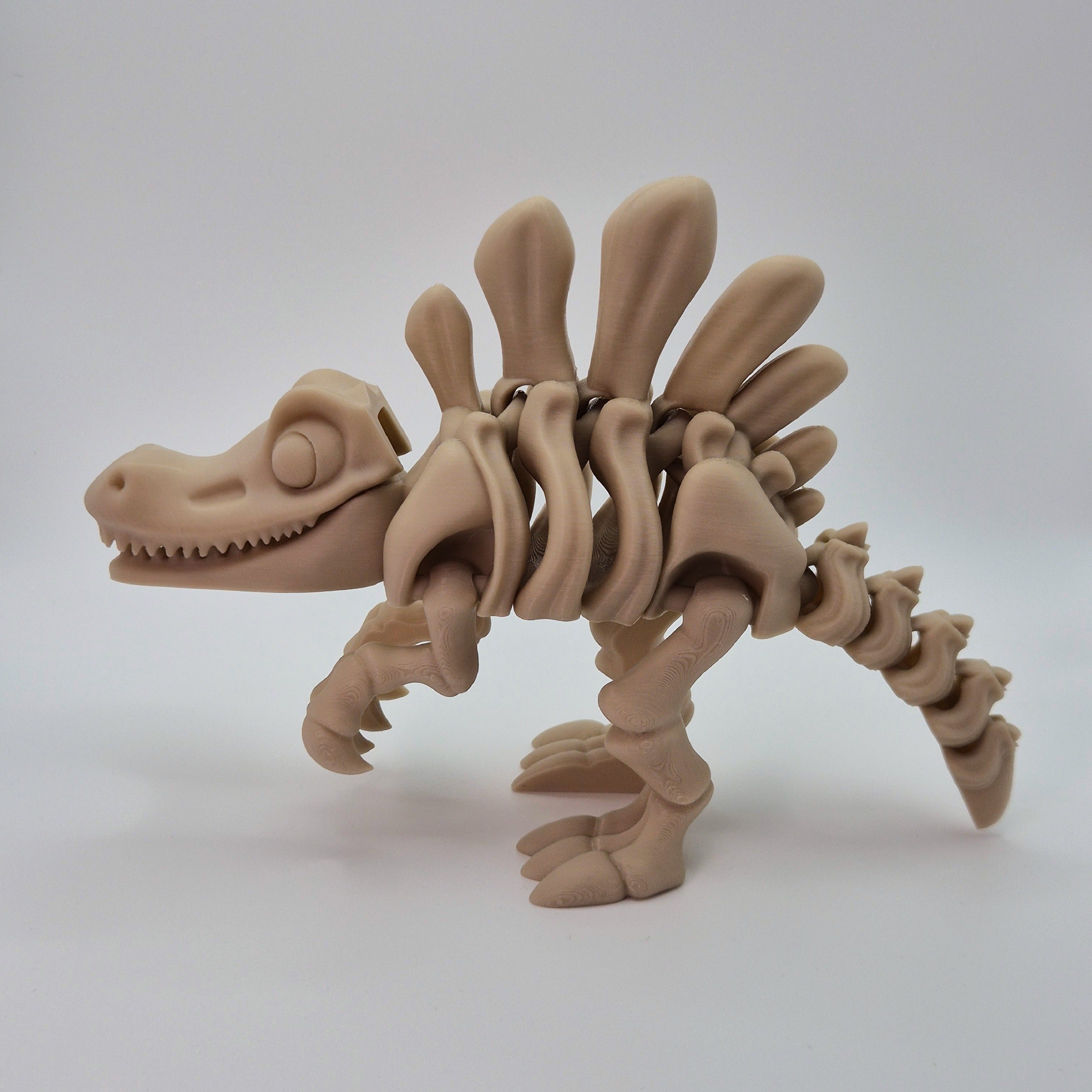 Side view of a bone-coloured 3D-printed articulating skeleton Spinosaurus toy
