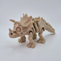 Angled front view of a bone-coloured 3D-printed articulating skeleton Triceratops toy