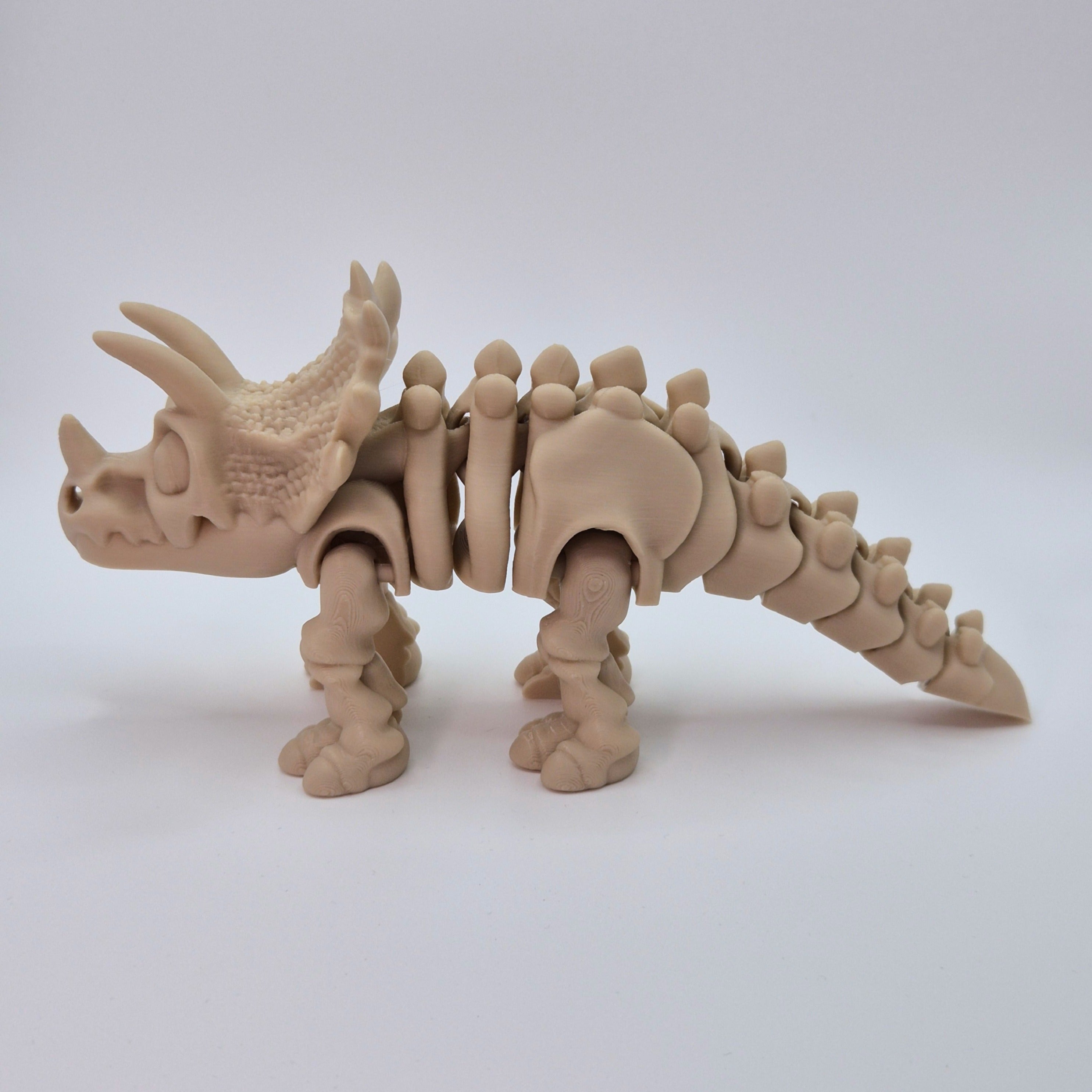 Side view of a bone-coloured 3D-printed articulating skeleton Triceratops toy