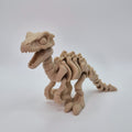 Angled front view of a bone-coloured 3D-printed articulating skeleton Velociraptor toy