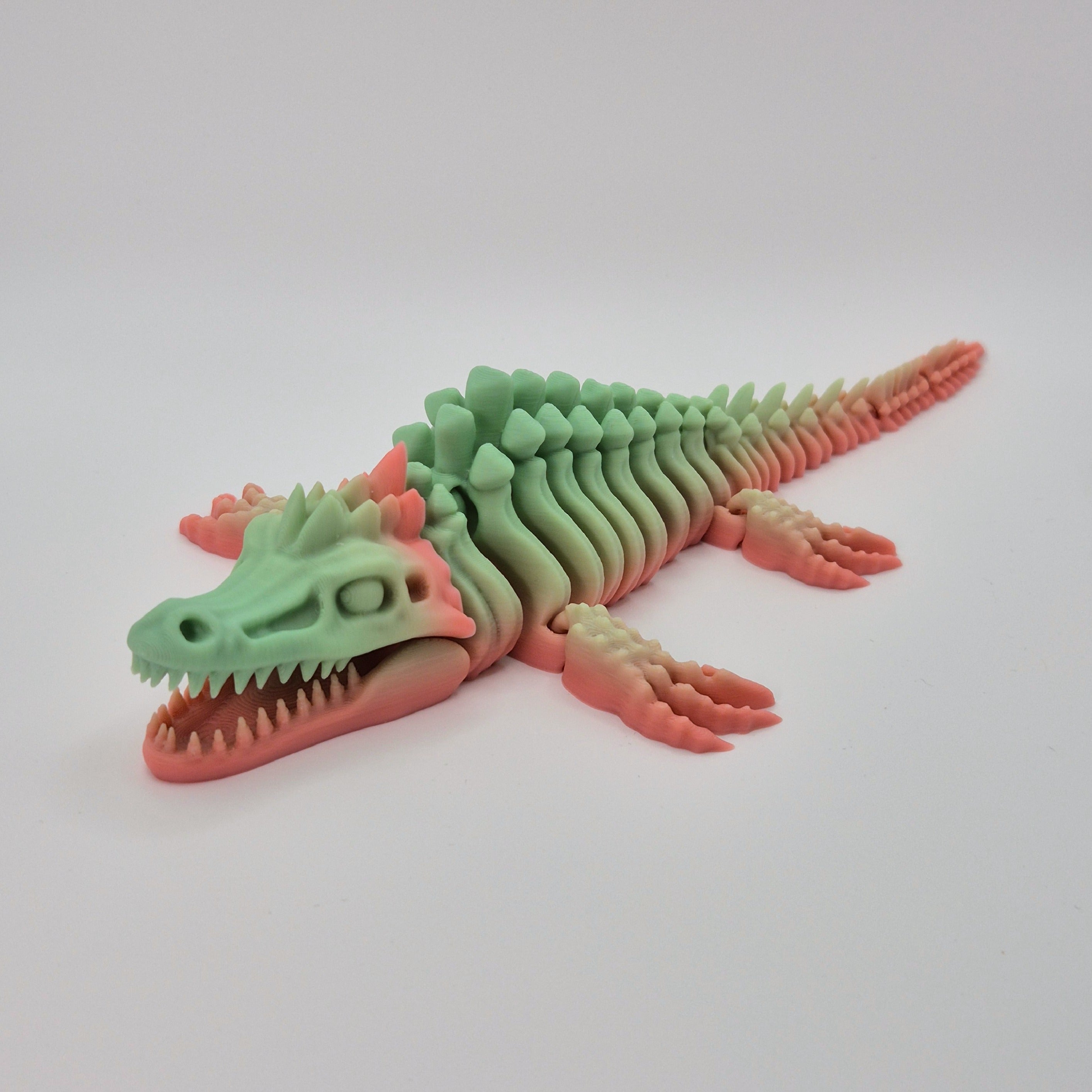 Angled front view of a sherbet-coloured 3D-printed articulating skeleton Mosasaurus toy